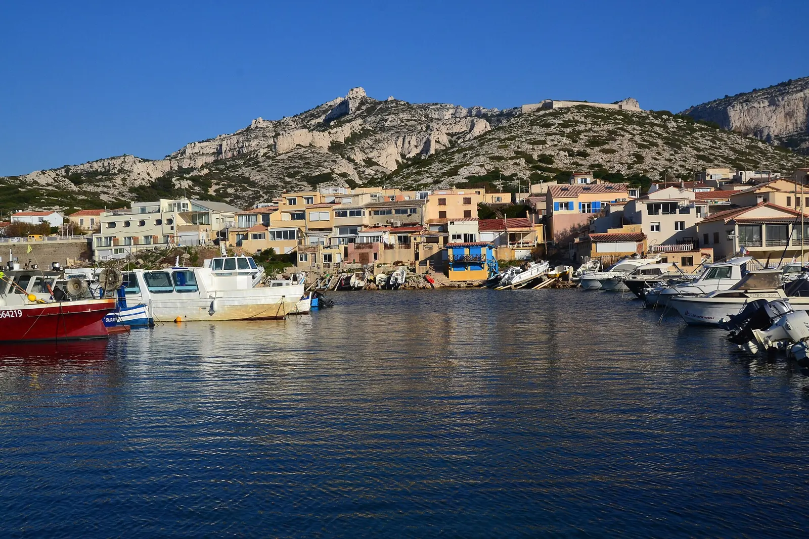 Le port des Goudes, ses barques et ses maisons au pied du massif